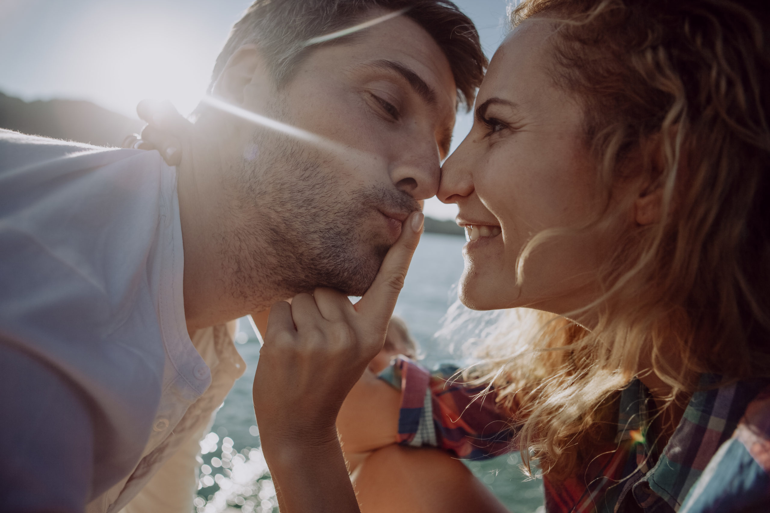 Happy, smiling couple on a date as man is leaning in for a first date kiss.