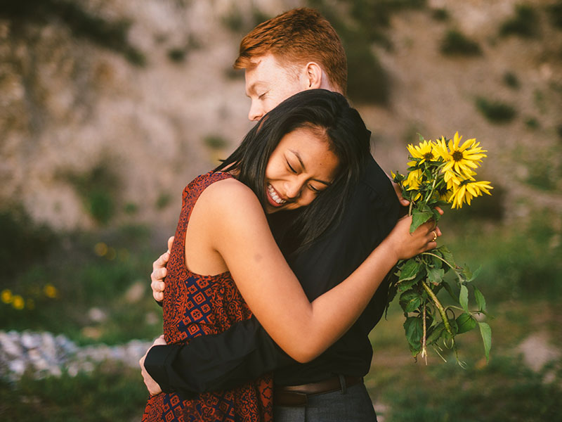 A girl and guy who are friends hugging.