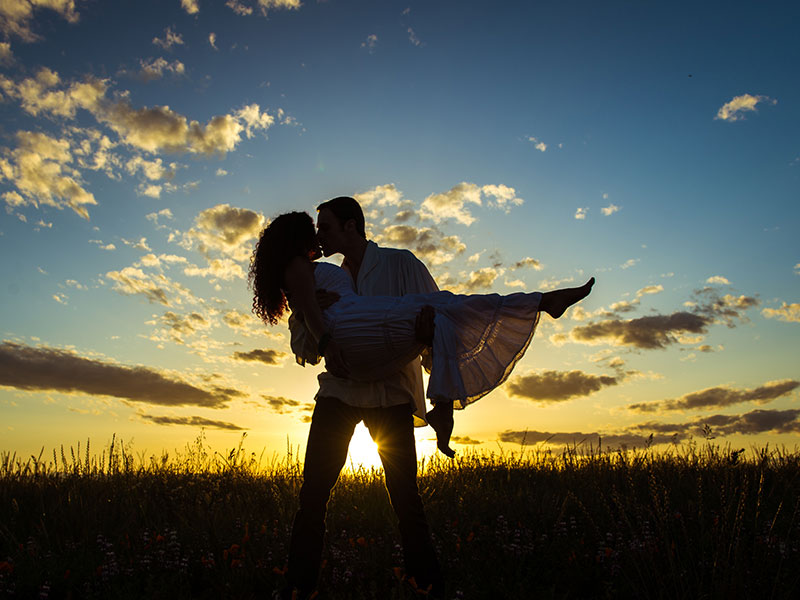 A couple in love kissing in a wheatfield in a classic love story style.