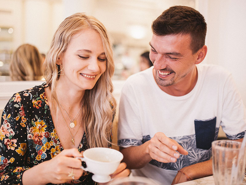 A couple chatting and laughing over coffee as they establish good communication in their relationship.