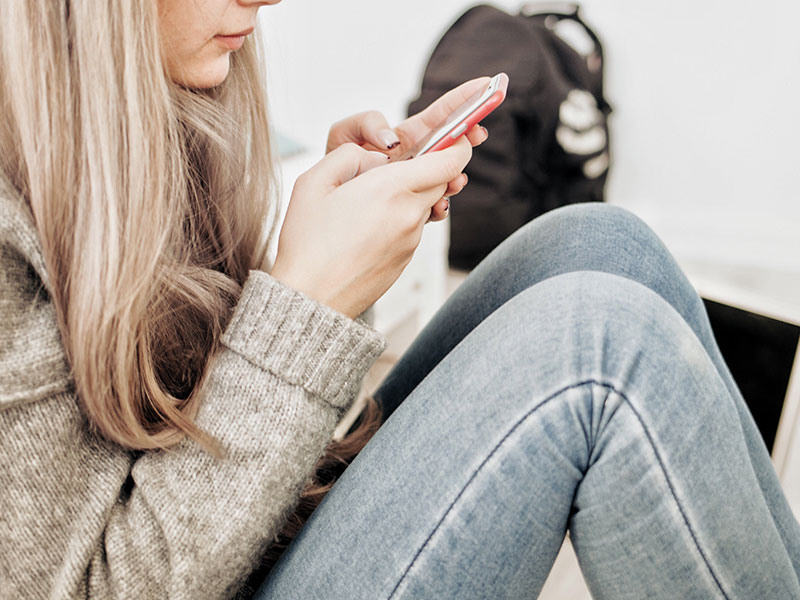 A woman texting on her phone and wondering if he texts me every day does that mean he likes me.