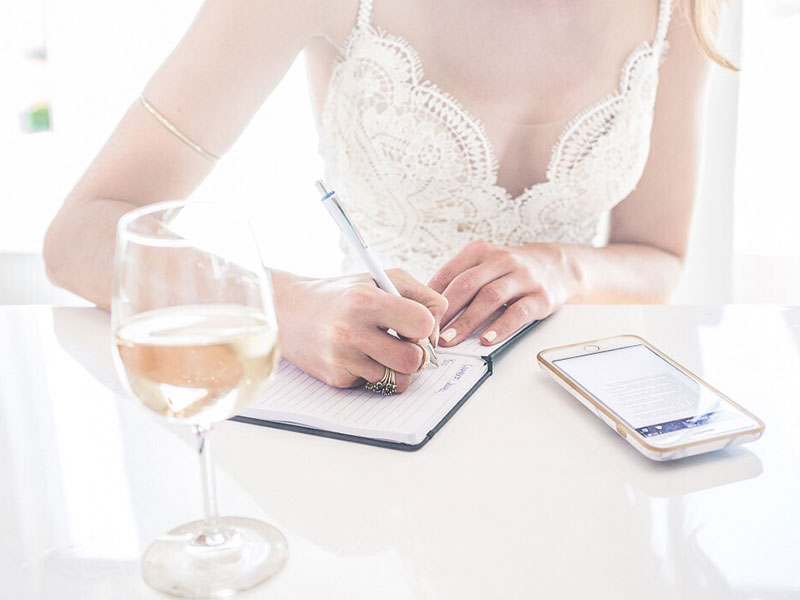 A woman writing one of these love letters for him while drinking a class of wine in the sun.