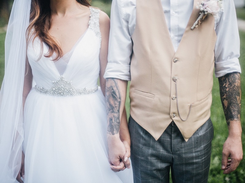 attractive newly wed couple holding hands and listening to marriage tips