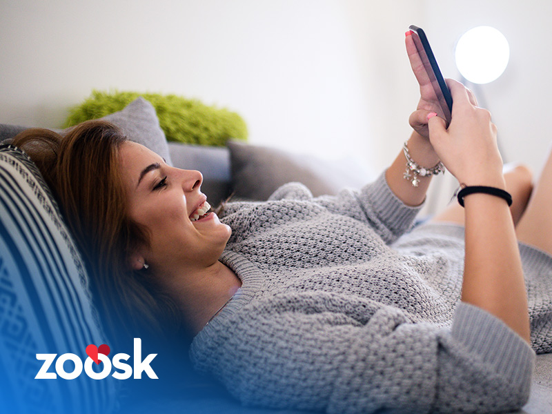Women laughing and using her Zoosk account on her mobile