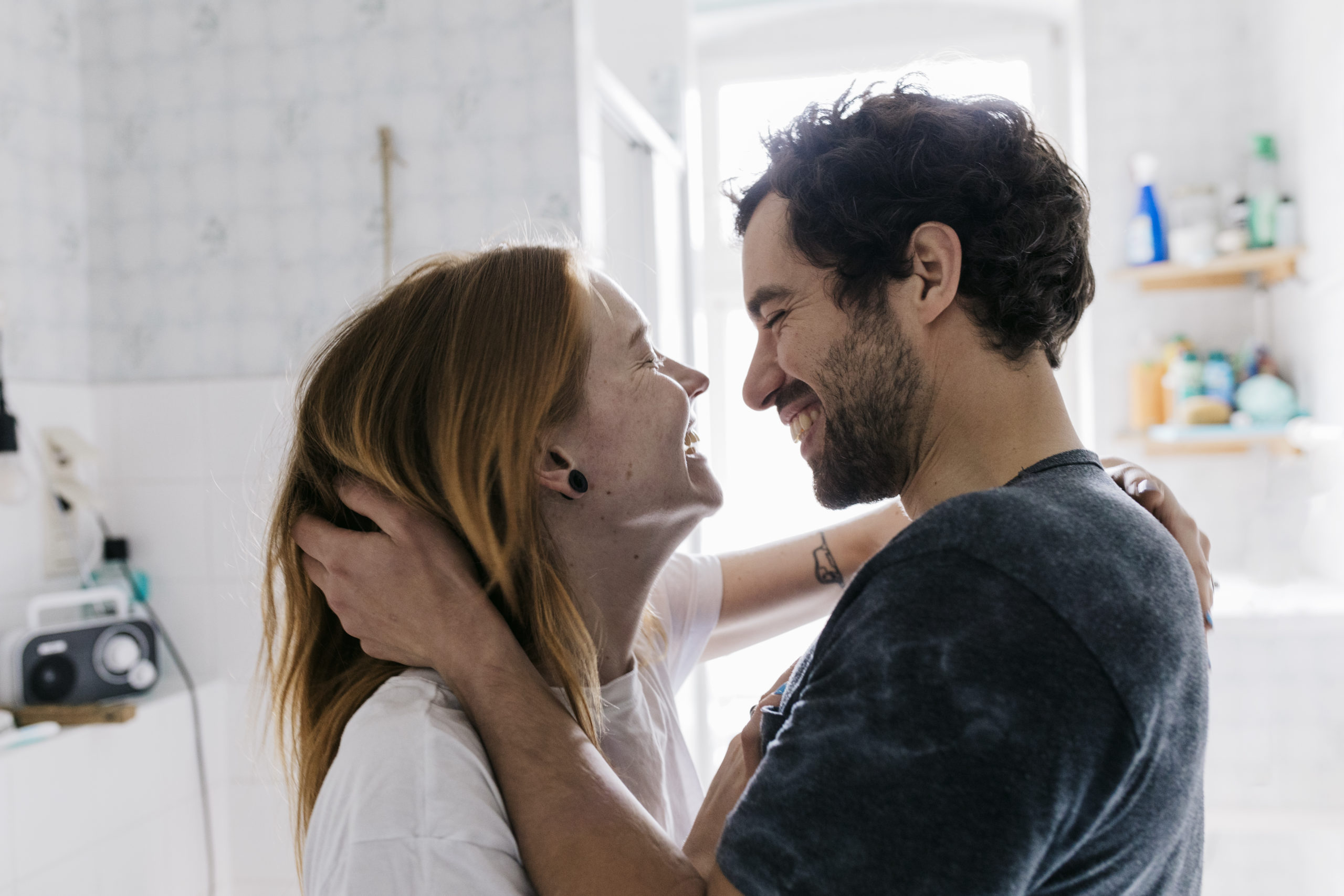 Couple smiling and affectionately embracing each other before kissing.